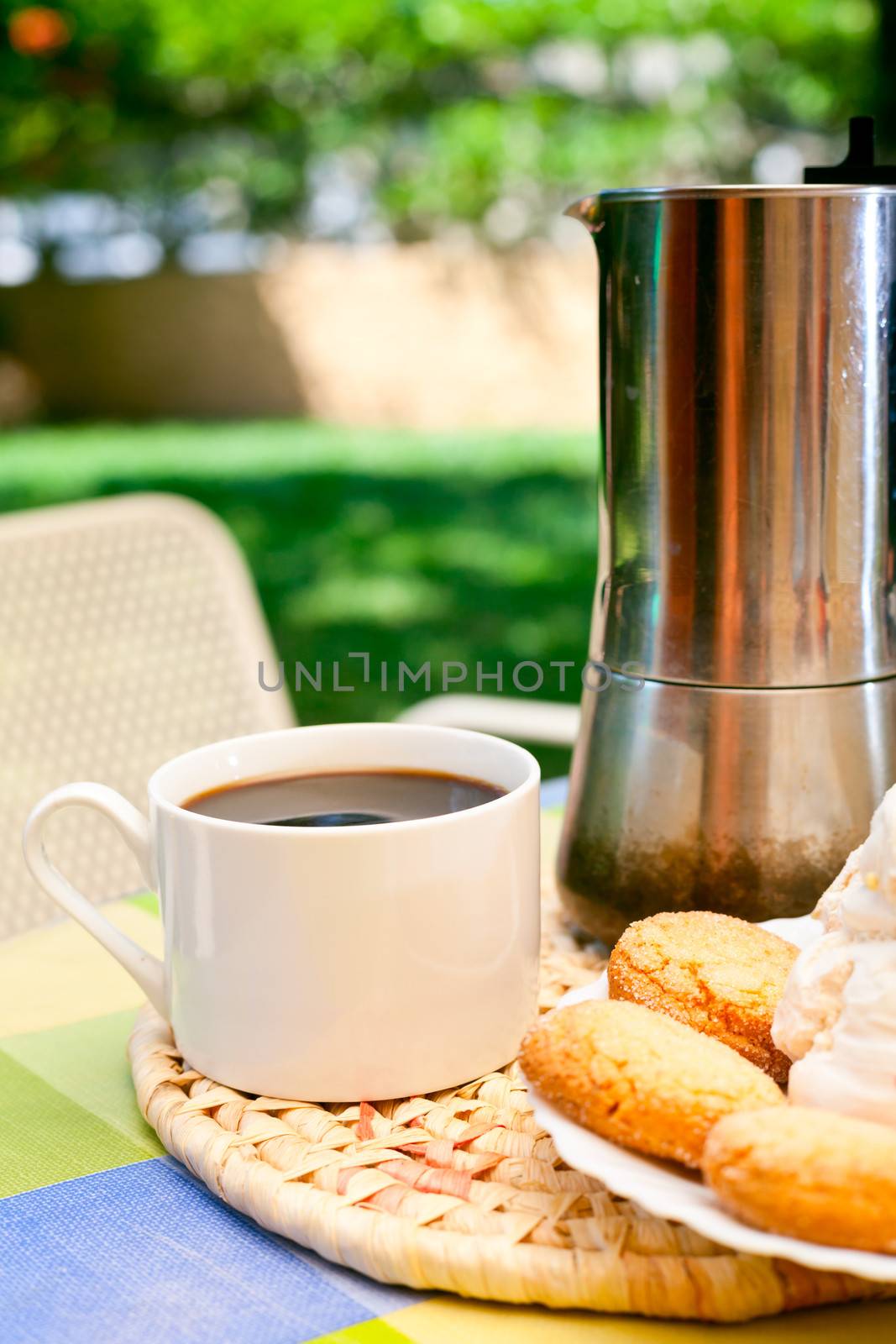Coffee cup with cookies and moka pot outdoors