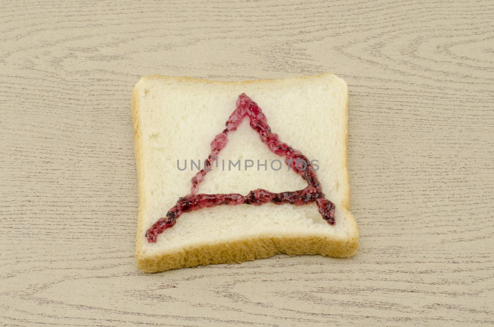 jam alphabet on sliced bread on wood background