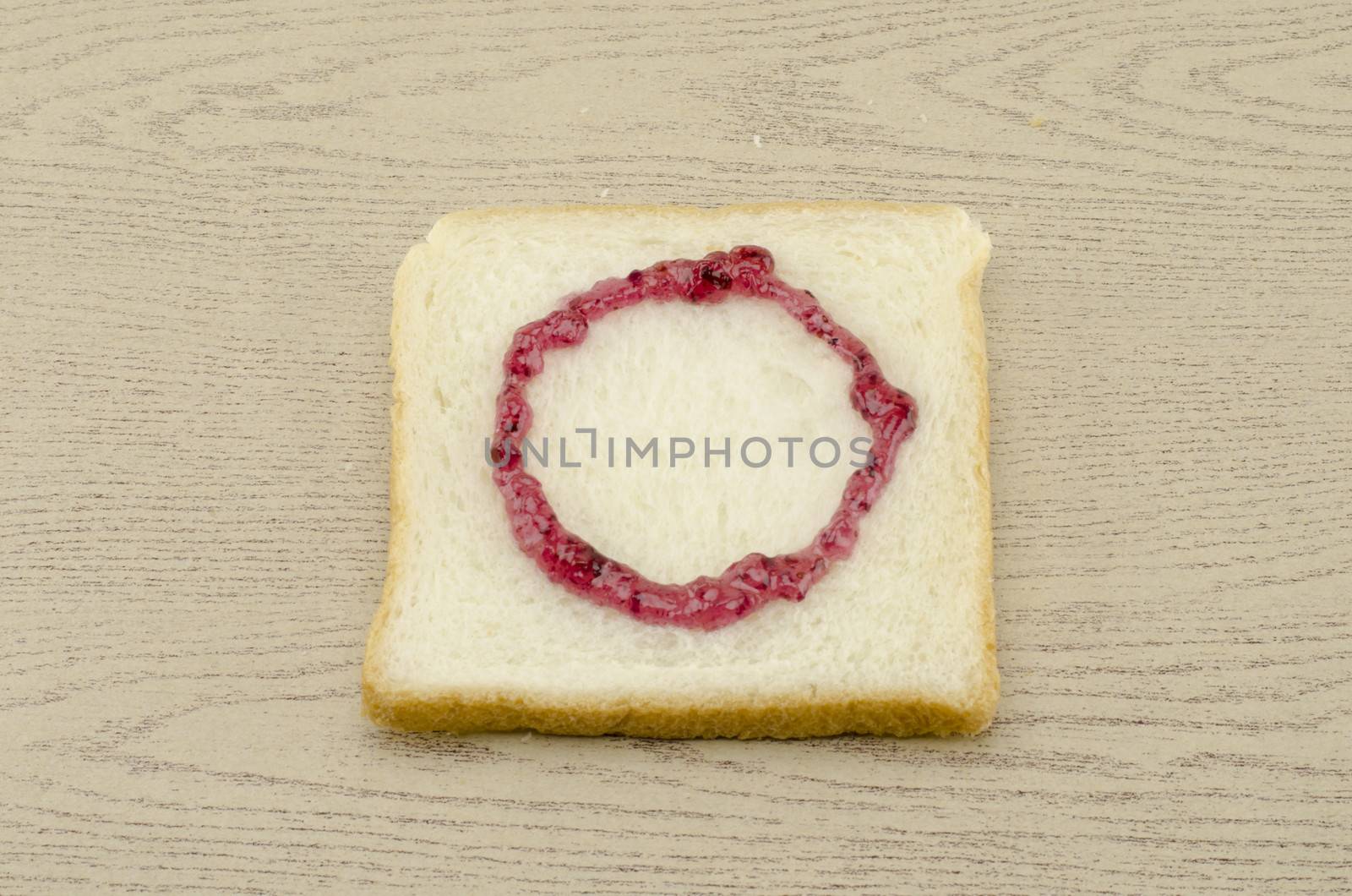 jam alphabet on sliced bread on wood background