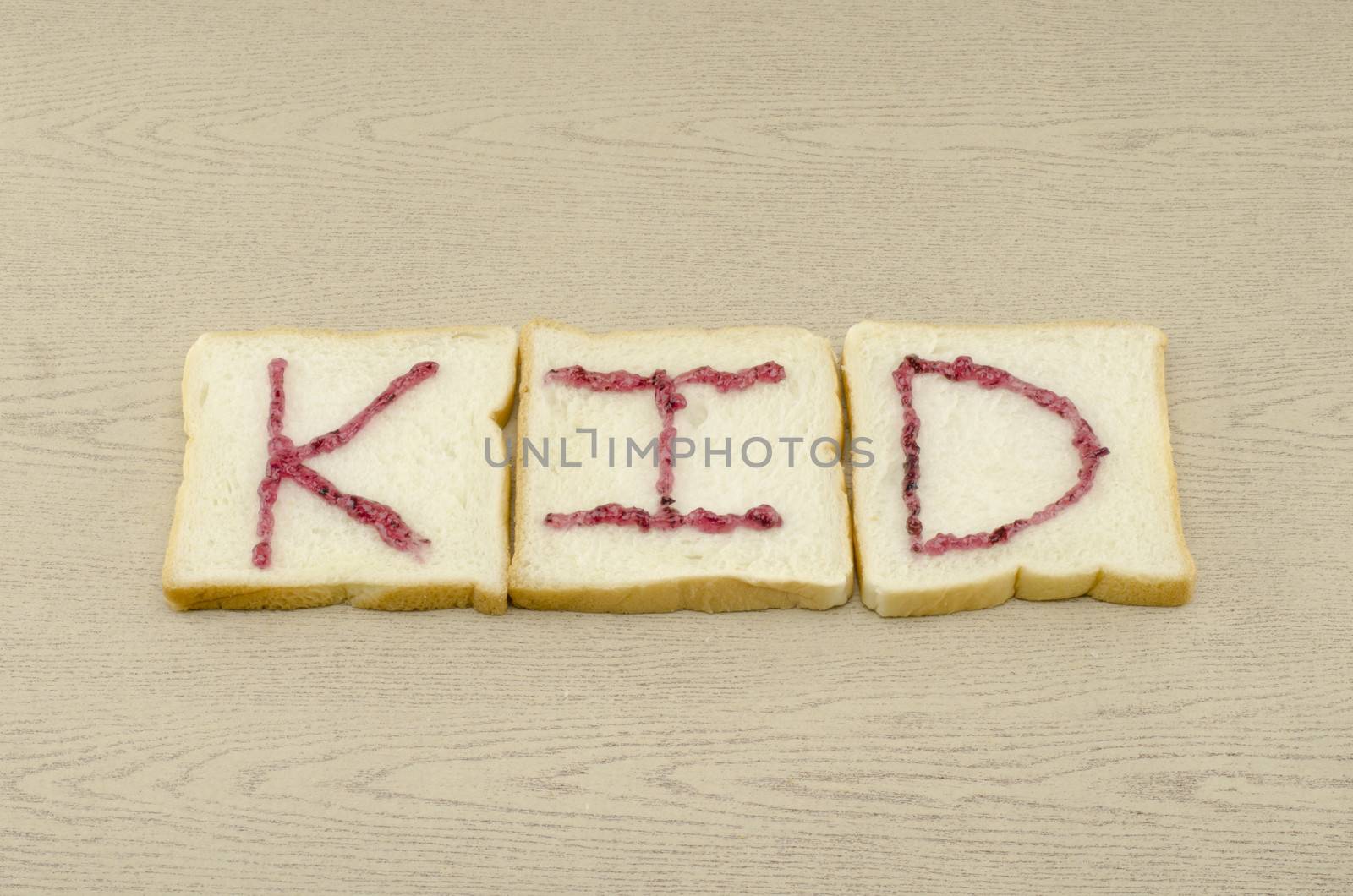 jam alphabet on sliced bread on wood background