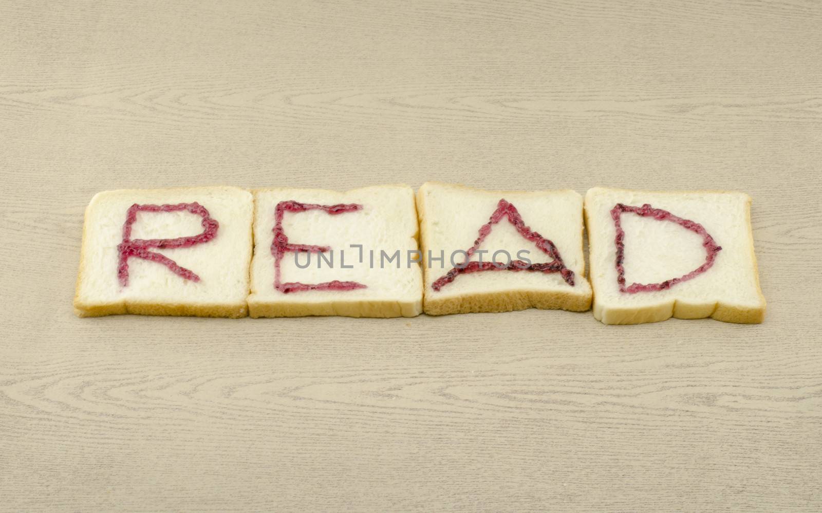 jam alphabet on sliced bread on wood background