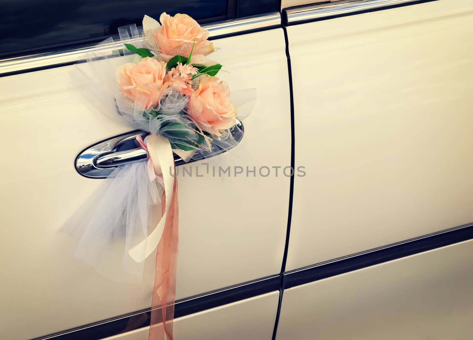 Door of white wedding car with flowers and white bow by Zhukow