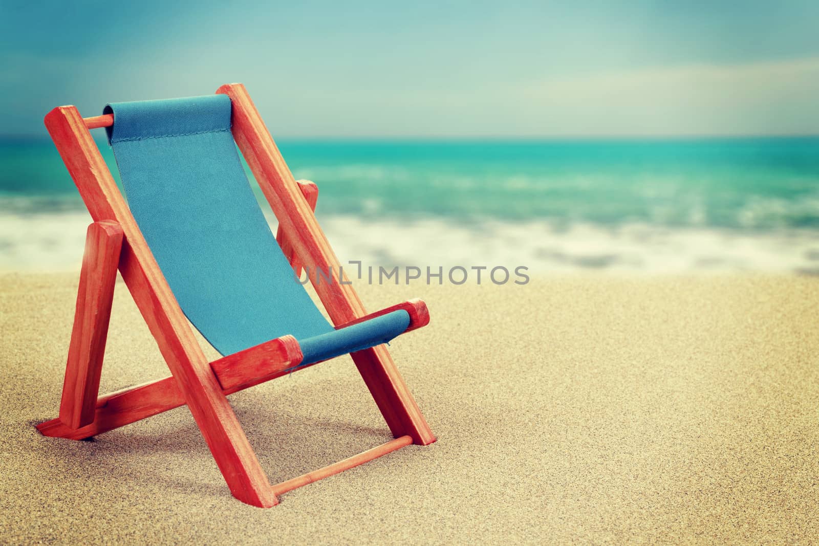 Vacation background with lounger in sandy beach vintage toned