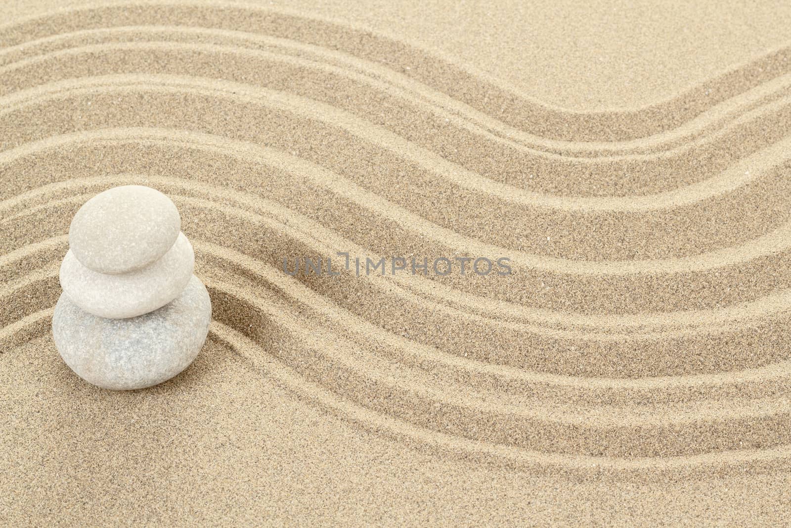 Balance of three zen stones in sand 