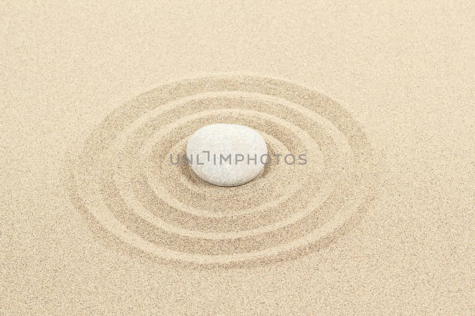 zen stones in soft sand with circles