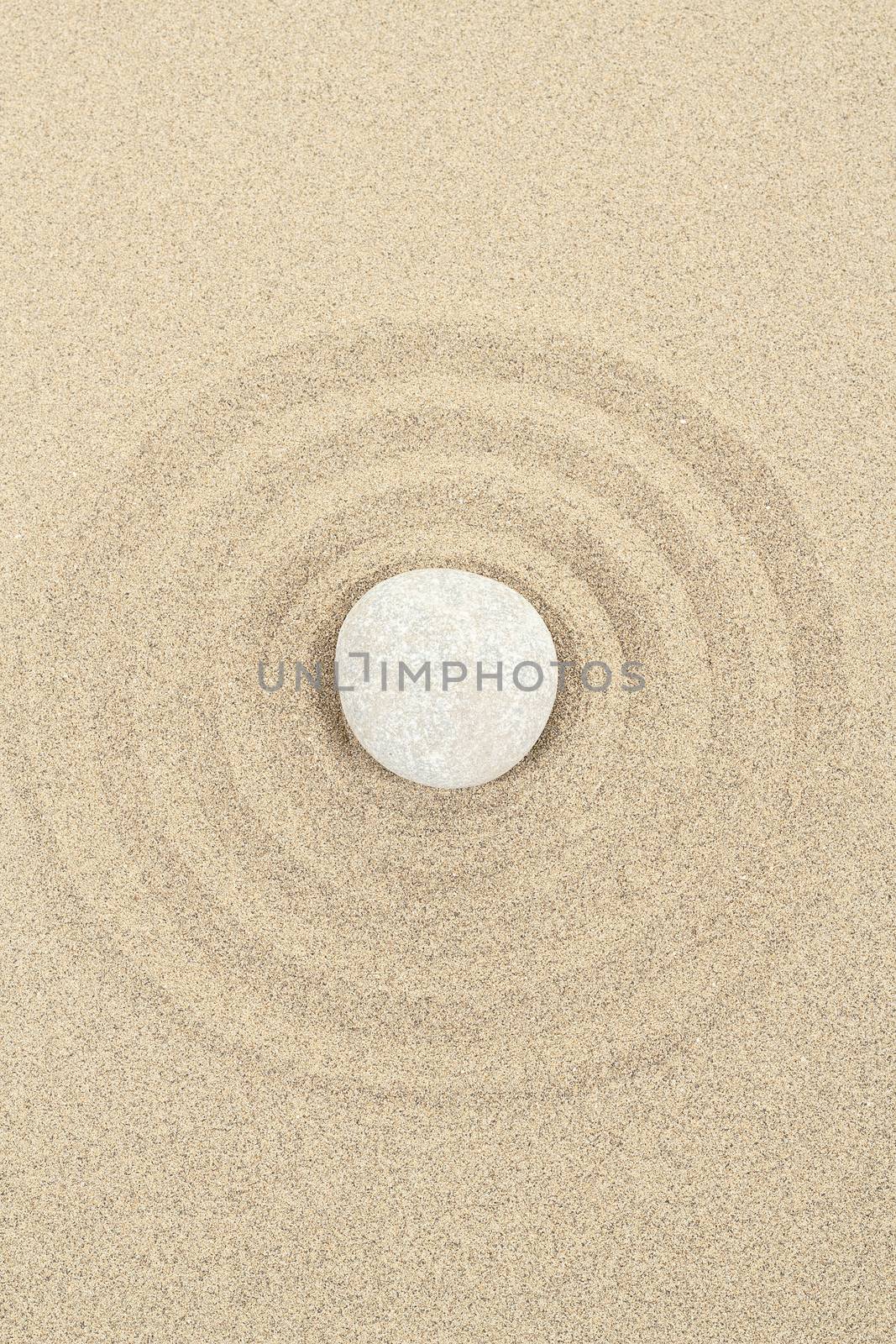 zen stones in soft sand with circles