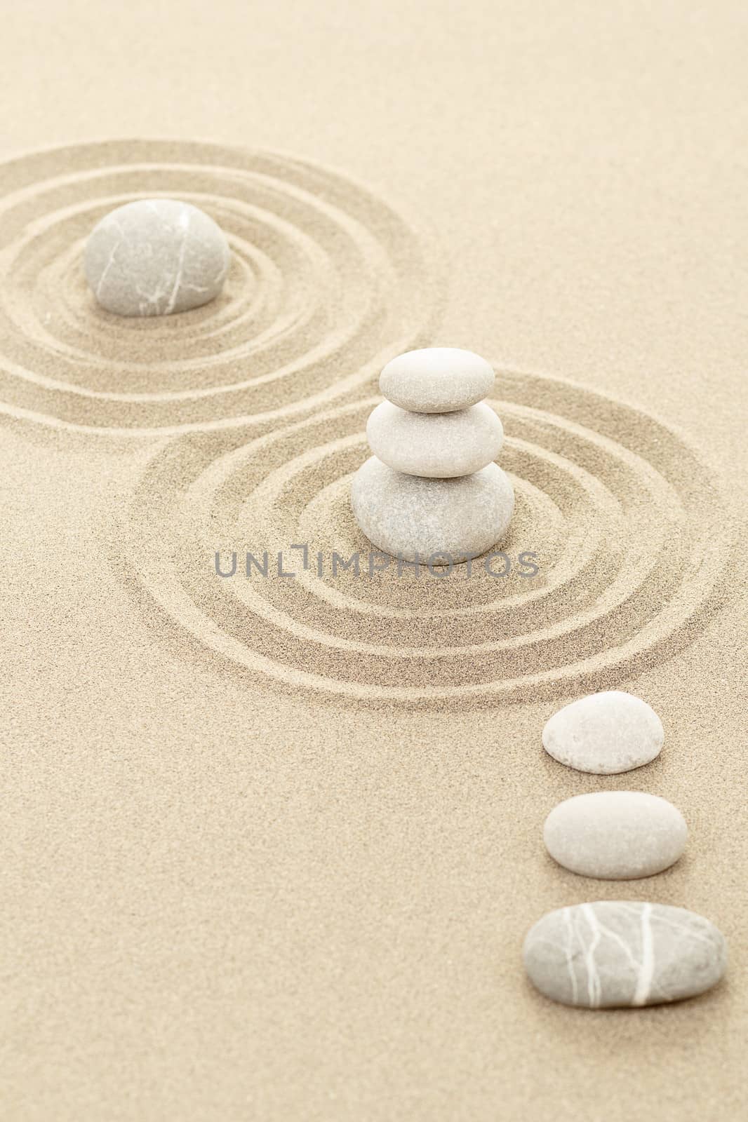Balance of three zen stones in sand 