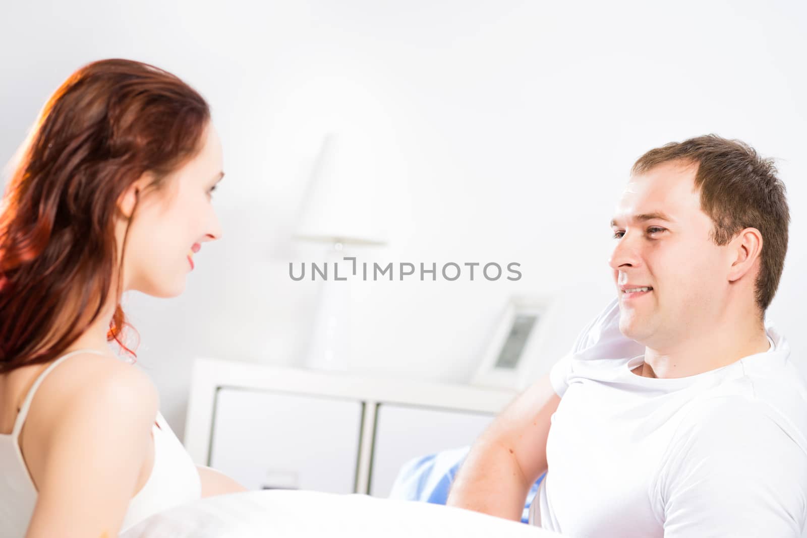 young man lying in bed with his girlfriend, spend time together at home