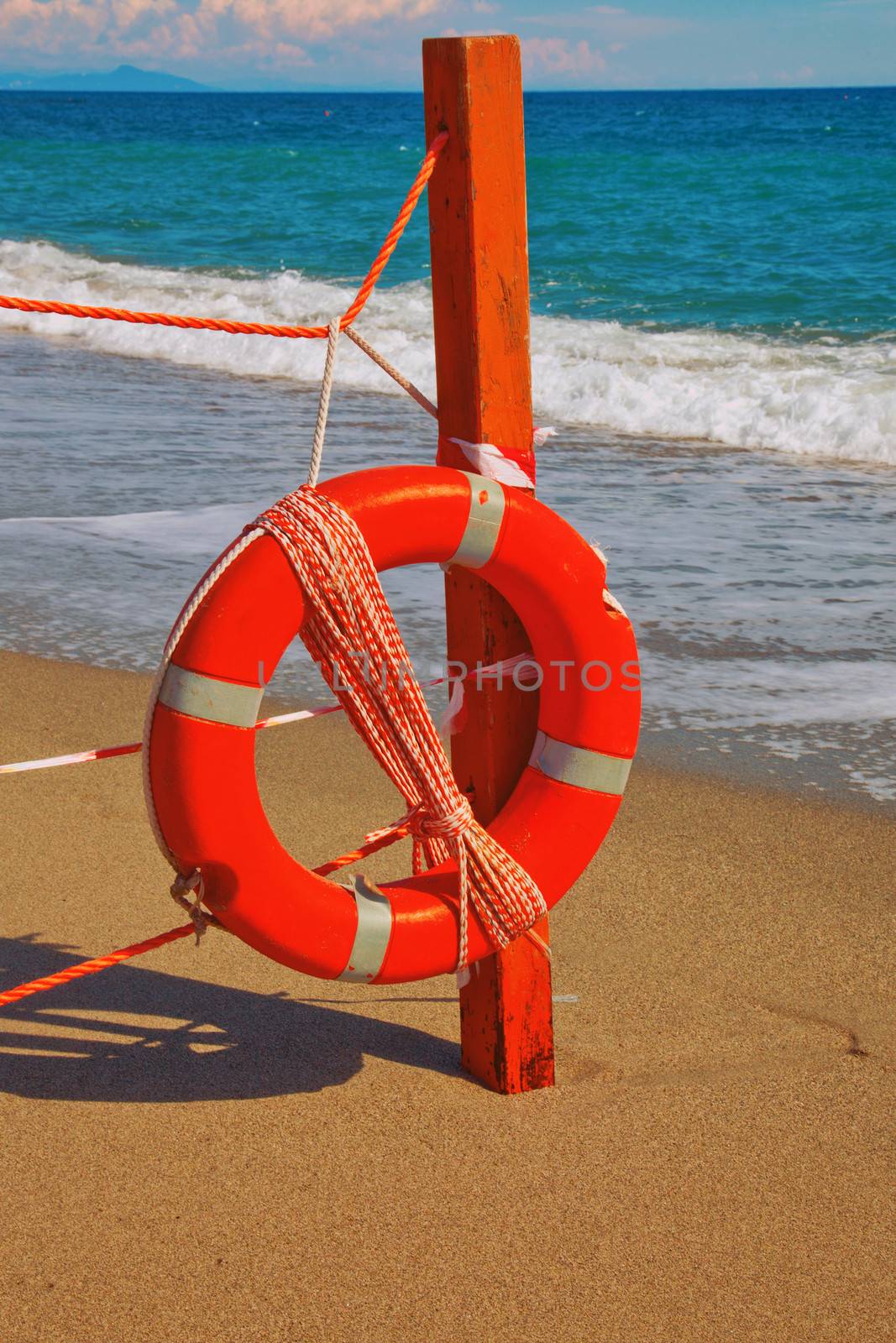 Life preserver hanging from a fence on a beach