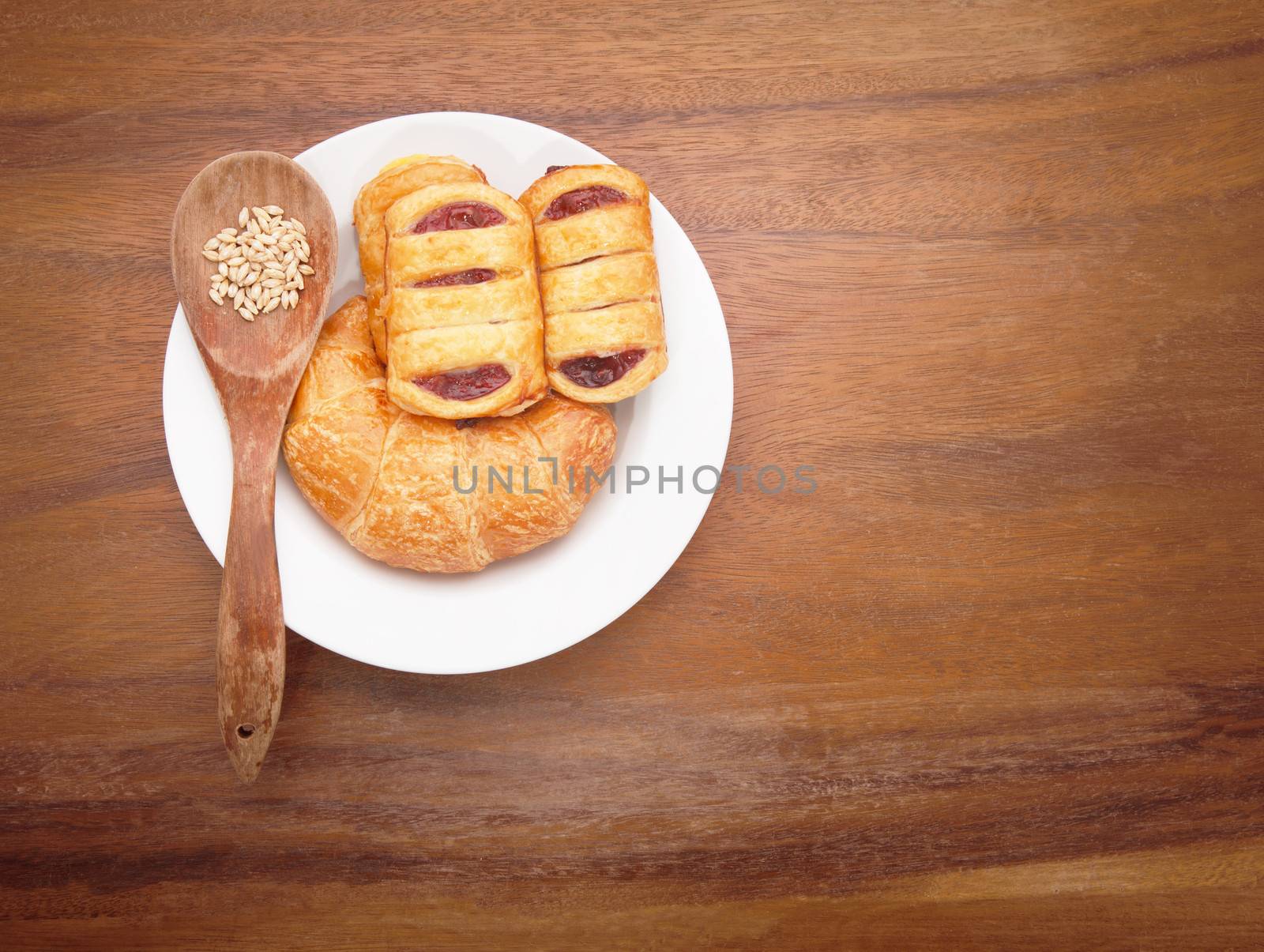 custard cake and croissant bread on white dish by khunaspix