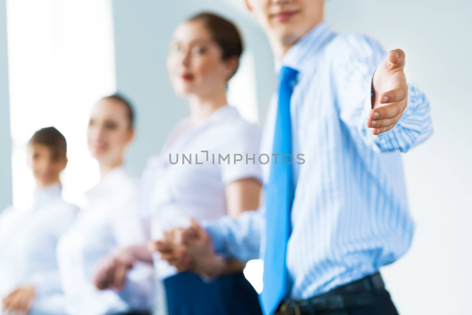 invitation to the team, the business man stretches out his hand, behind him a number of young businessmen