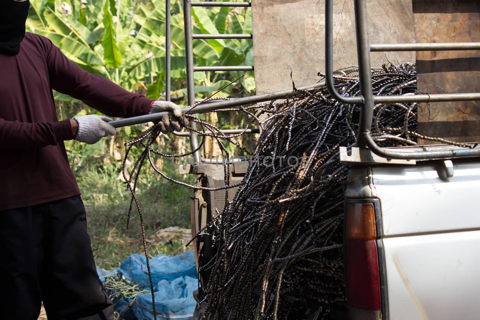 Thai people pull leftover of iron surplus in pickup truck by photo2life