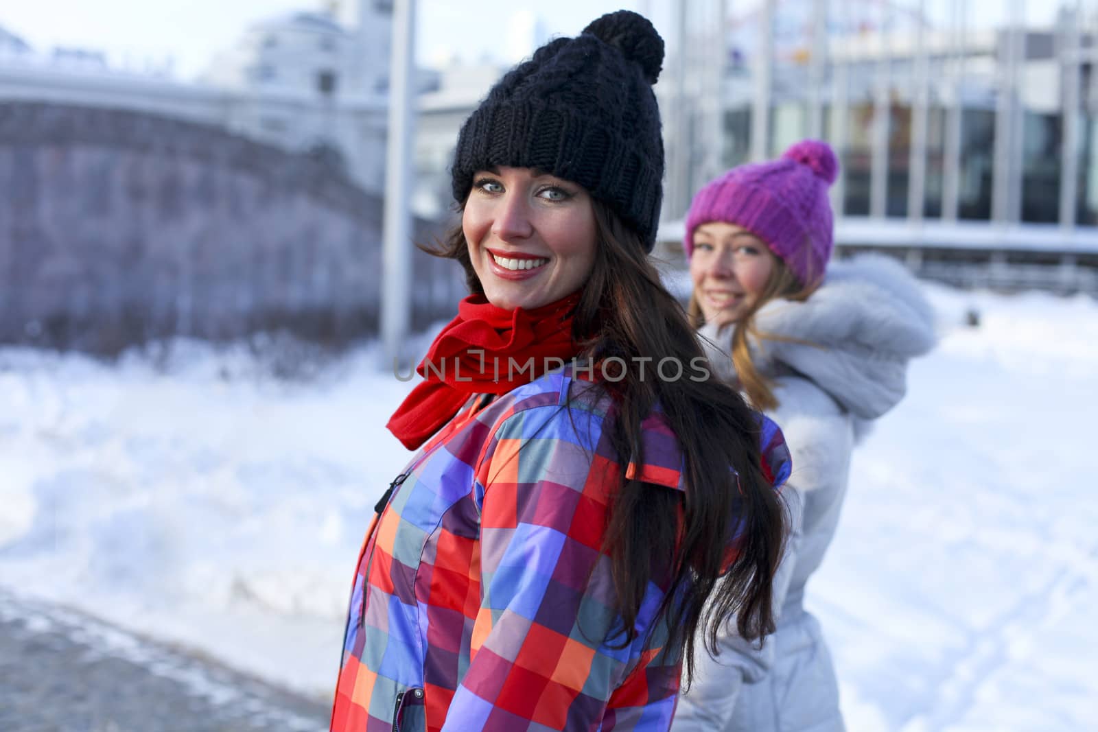 Happy young couple women in winter street