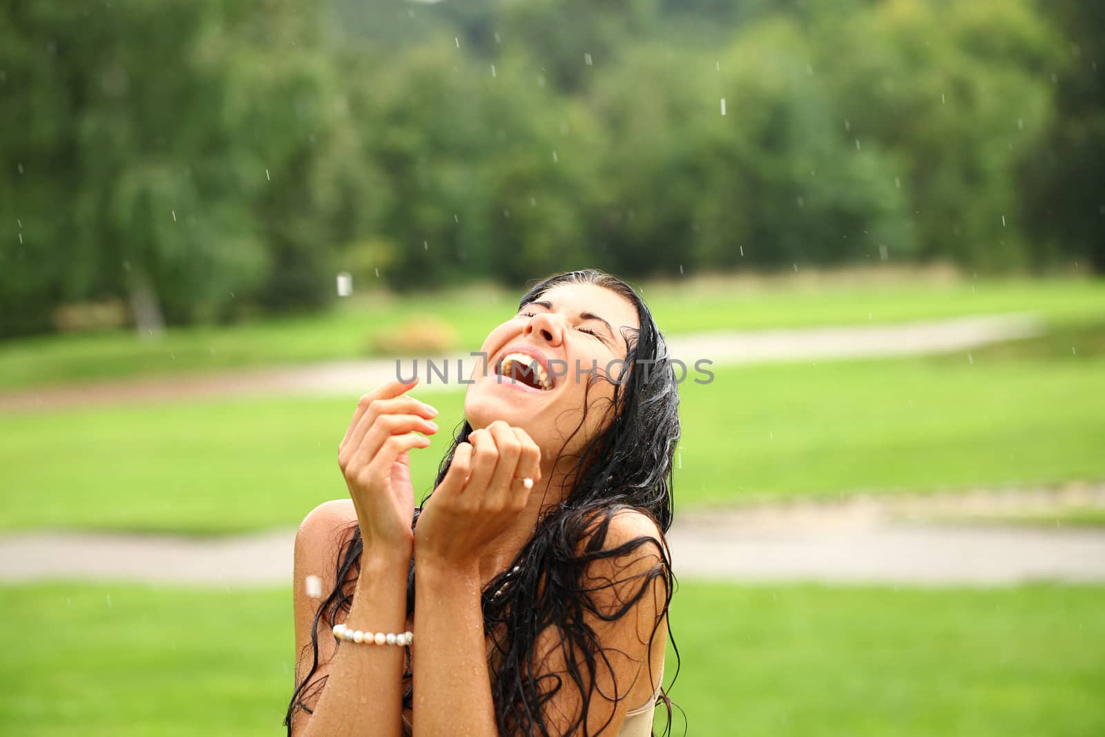 Young happy woman walking in the rain