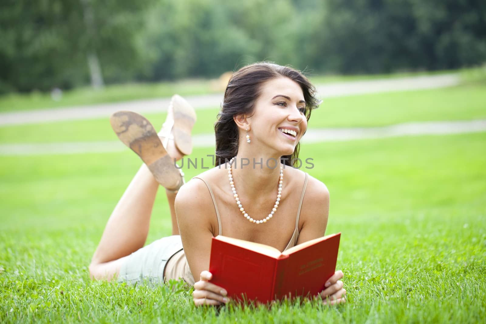 Young beautiful girl reading a book outdoor