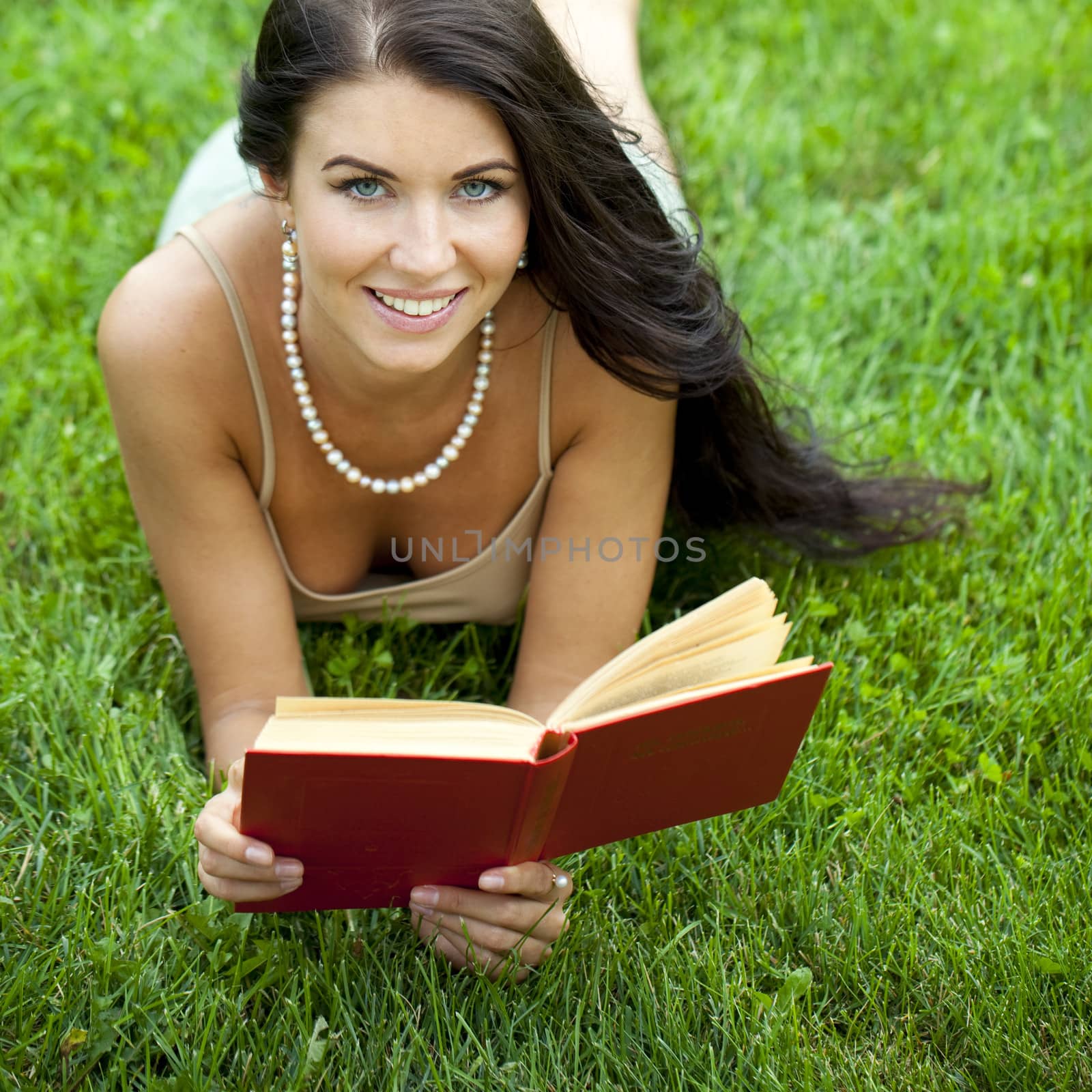 Young beautiful young woman reading a book outdoor by andersonrise