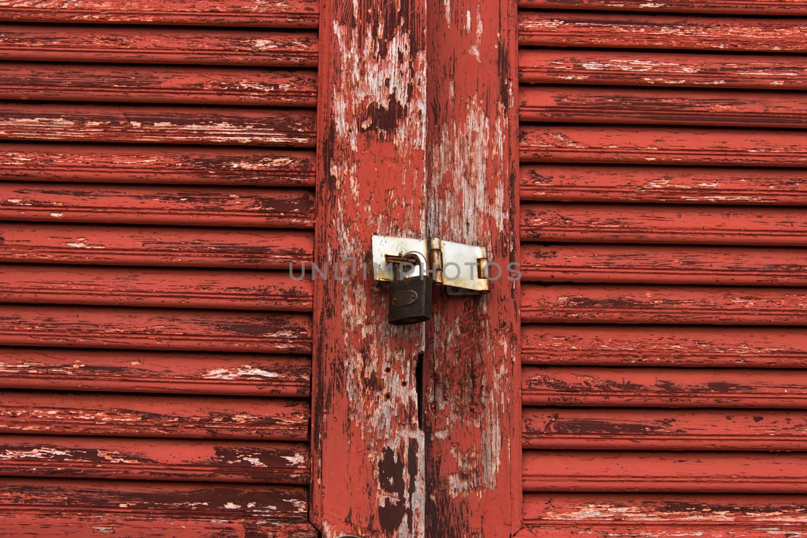 Old door red wood  peeling paint and key