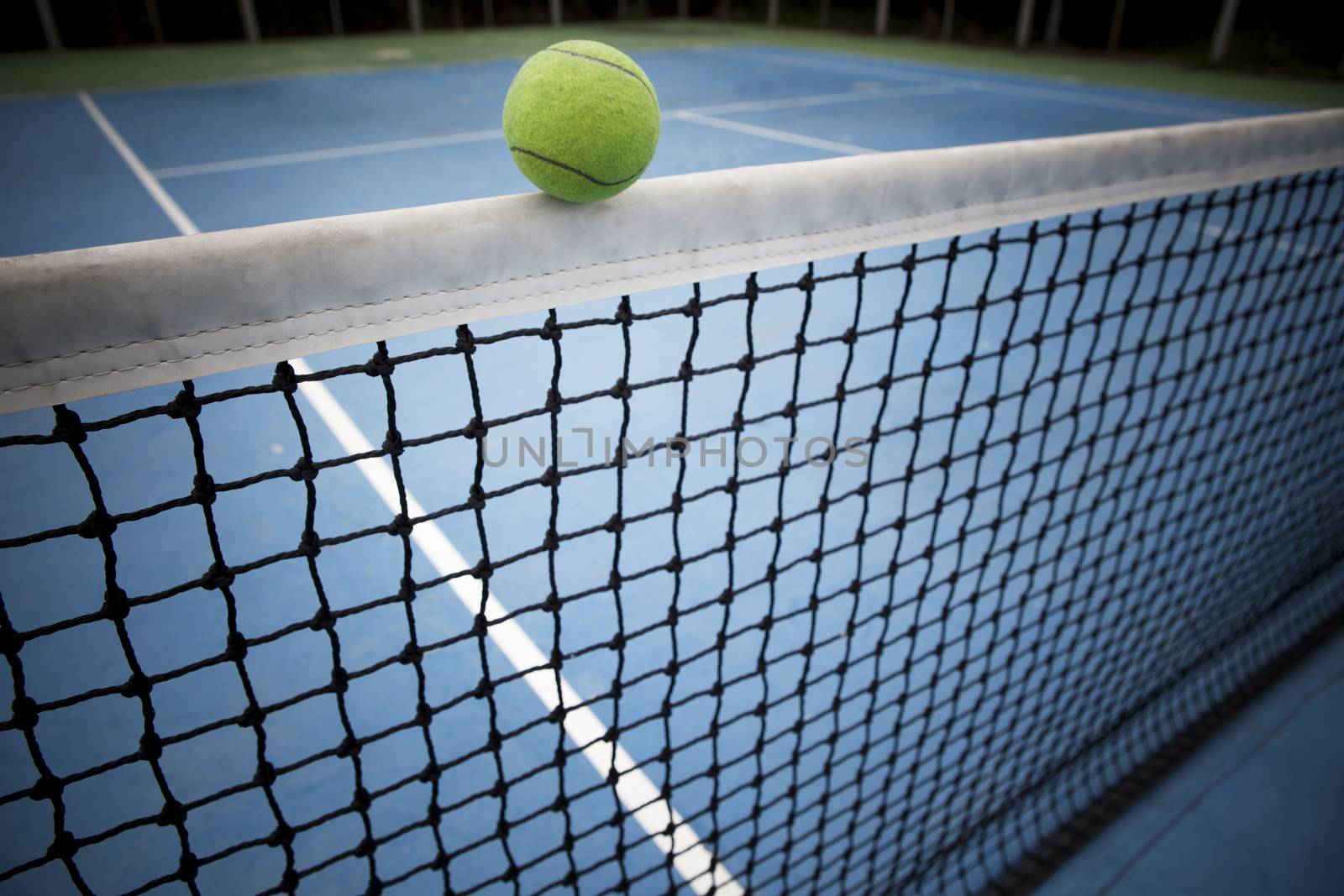tennes ball over black net  by khunaspix