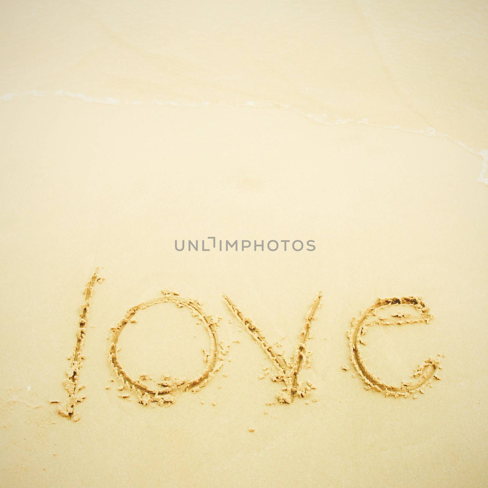 Hand written love on sand and beach