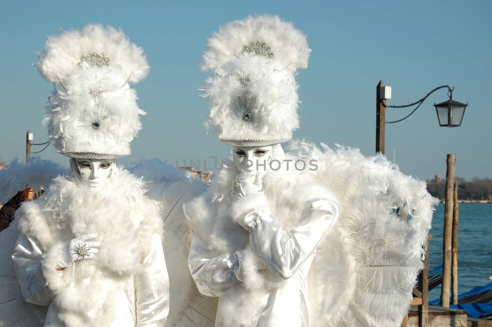 VENICE - MARCH 8:Two masks -white angels at St. Mark's Square during the Carnival of Venice on March 8, 2011.The annual carnival was held in 2011 from February 26th to March 8th