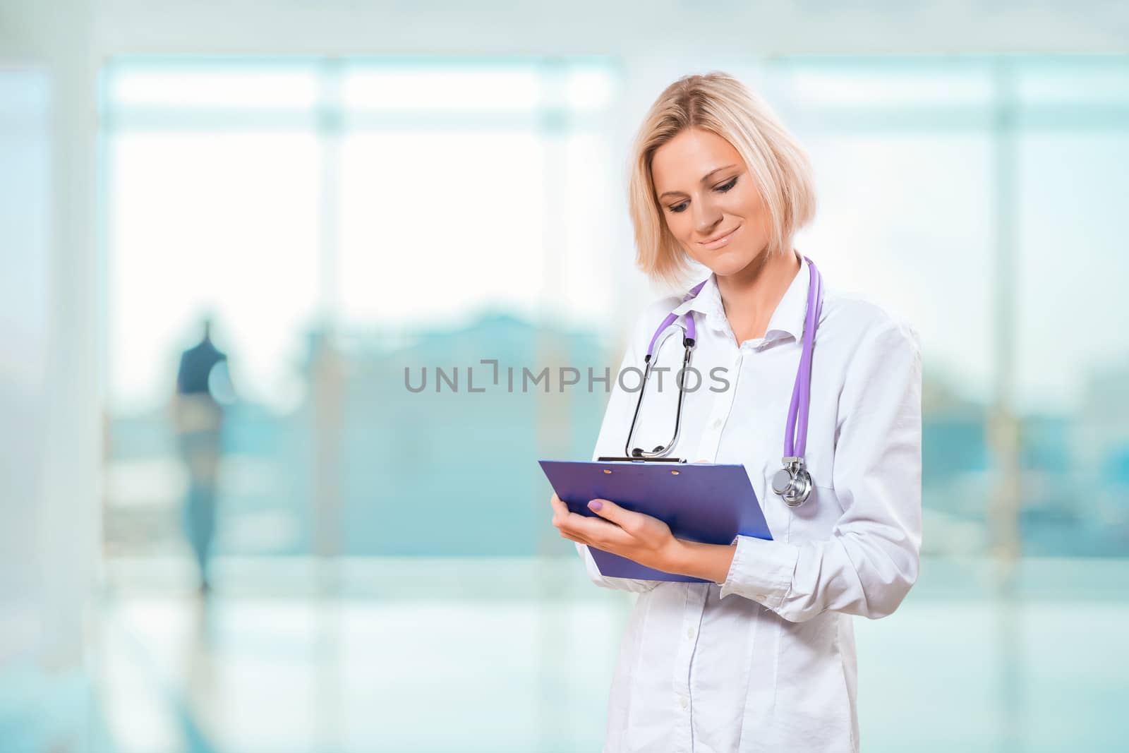 female doctor writng in clipboard