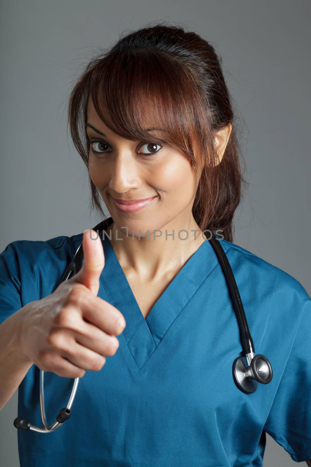 Attractive Indian doctor woman posing in a studio in front of a background