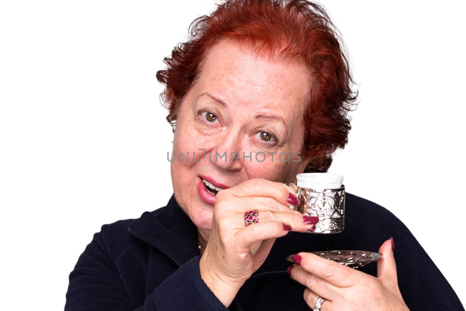 Senior woman welcomingly holding a silver Turkish coffee cup