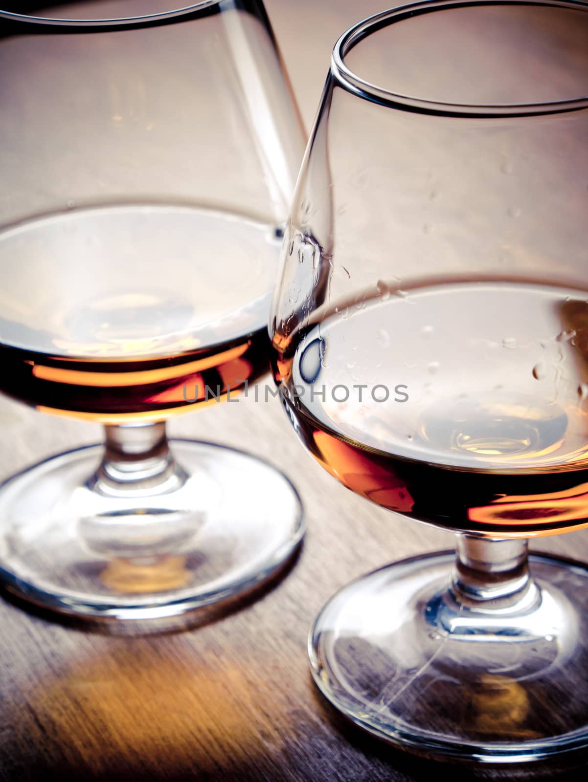 Two glasses of cognac on a wooden table