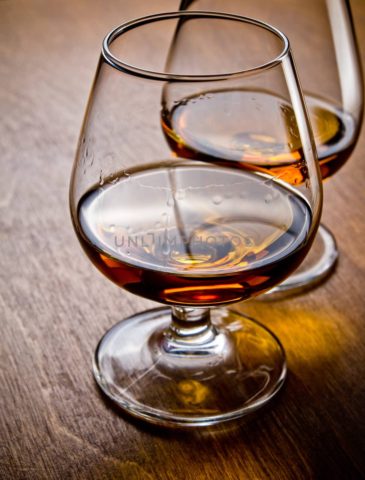 Two glasses of cognac on a wooden table