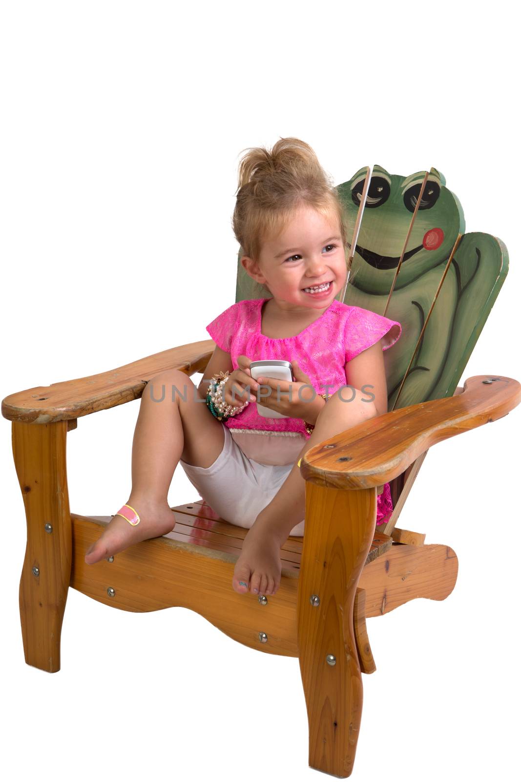 Pretty Young Toddler Showing her happey feelings on a beach chair while holding a cell phone, perhaps she received good news