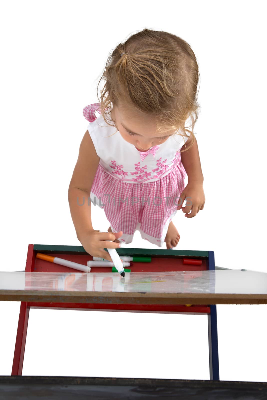 Little toddler girl writing on to a white board shot from top