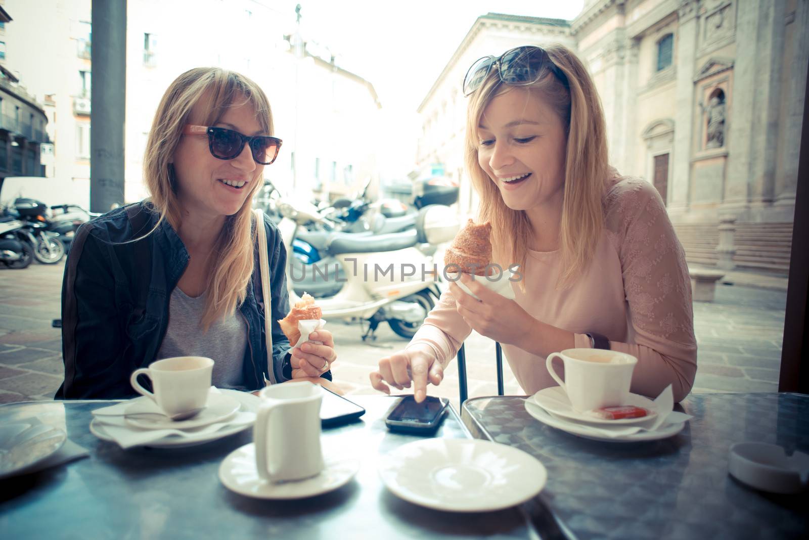 two beautiful blonde women talking at the bar by peus
