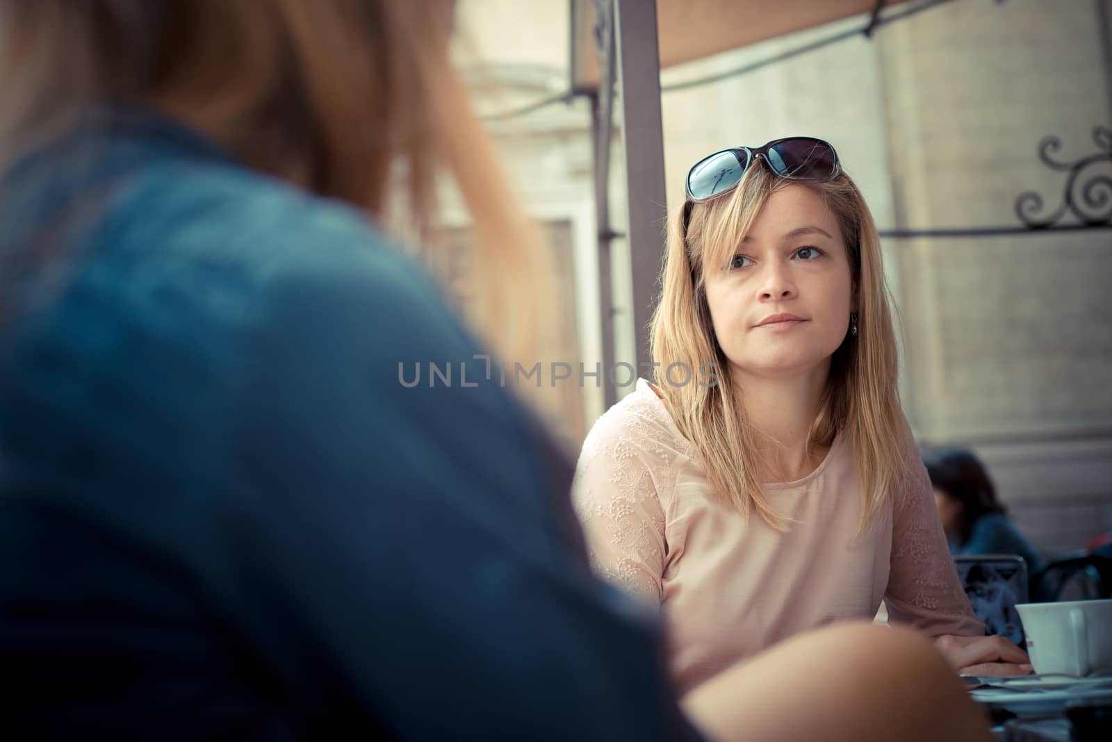 two beautiful blonde women talking at the bar by peus