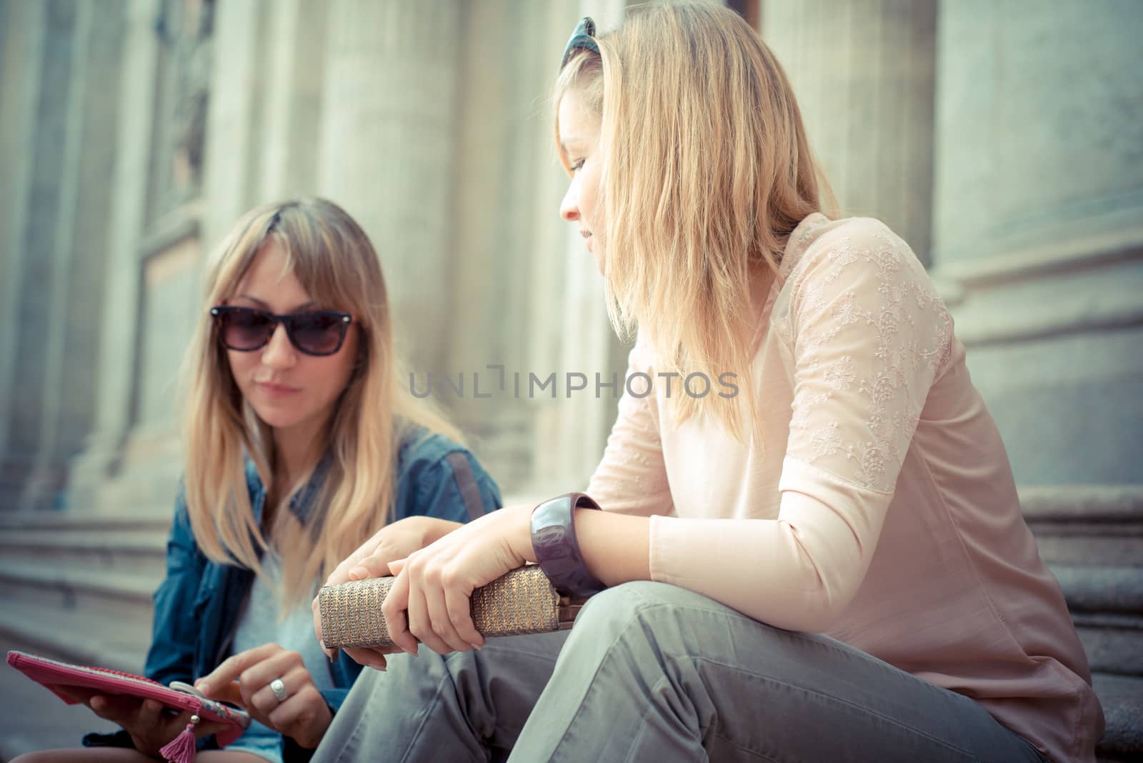 two beautiful blonde women talking in the city