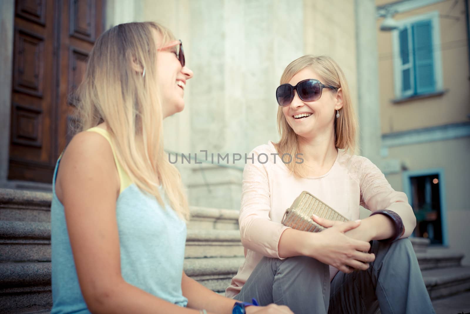 two beautiful blonde women talking in the city