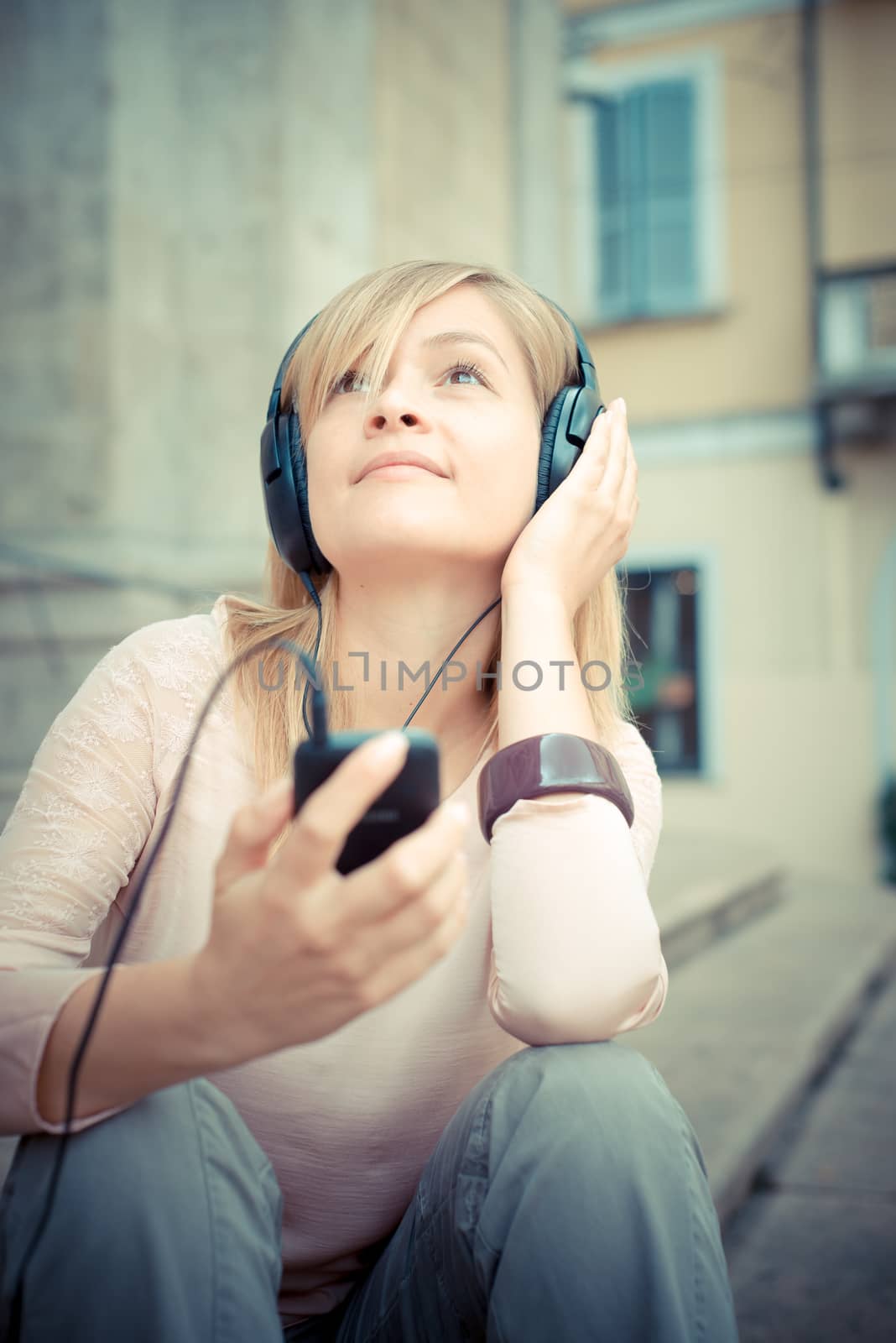 beautiful blonde woman listening to music by peus