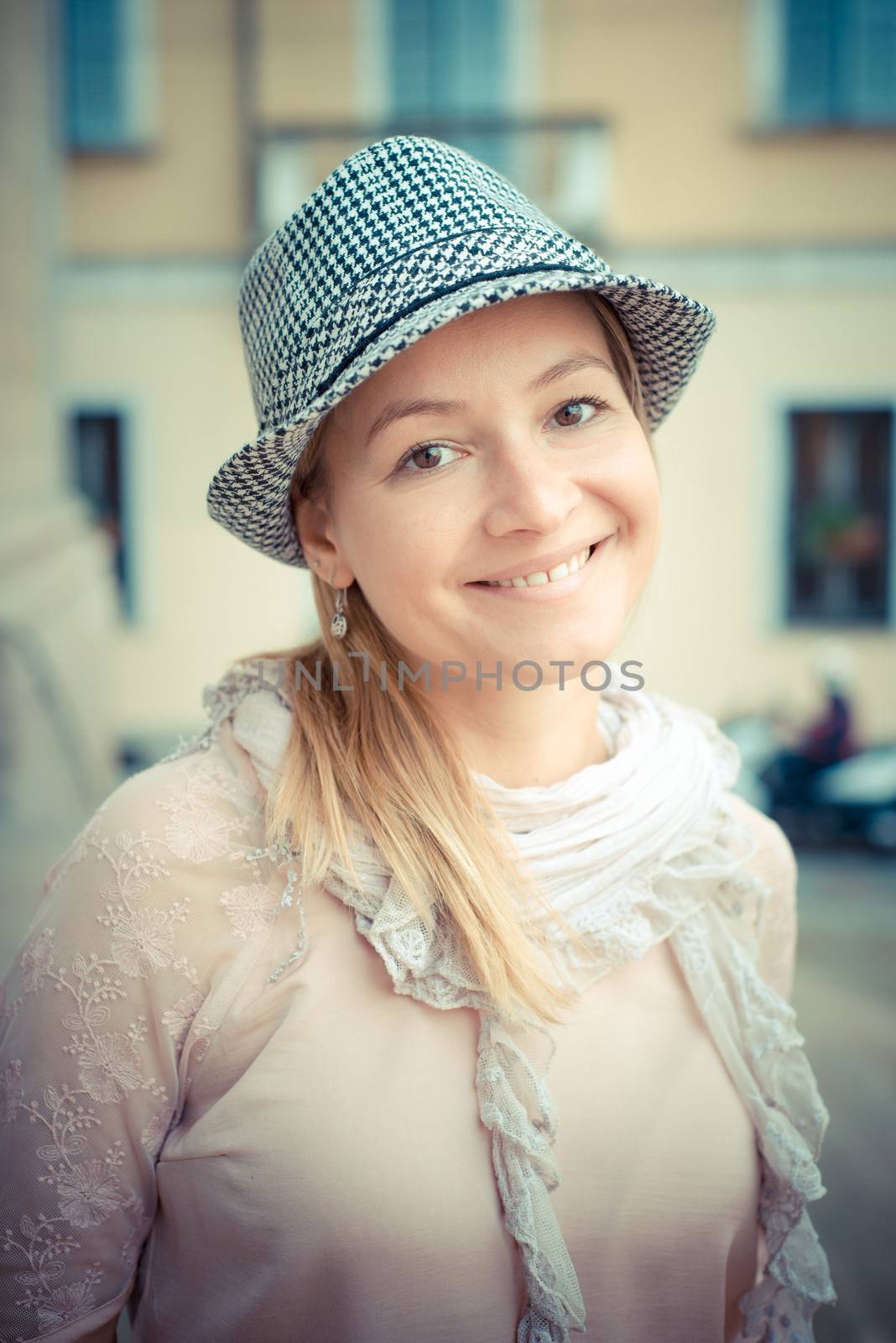 beautiful blonde woman with hat in the city