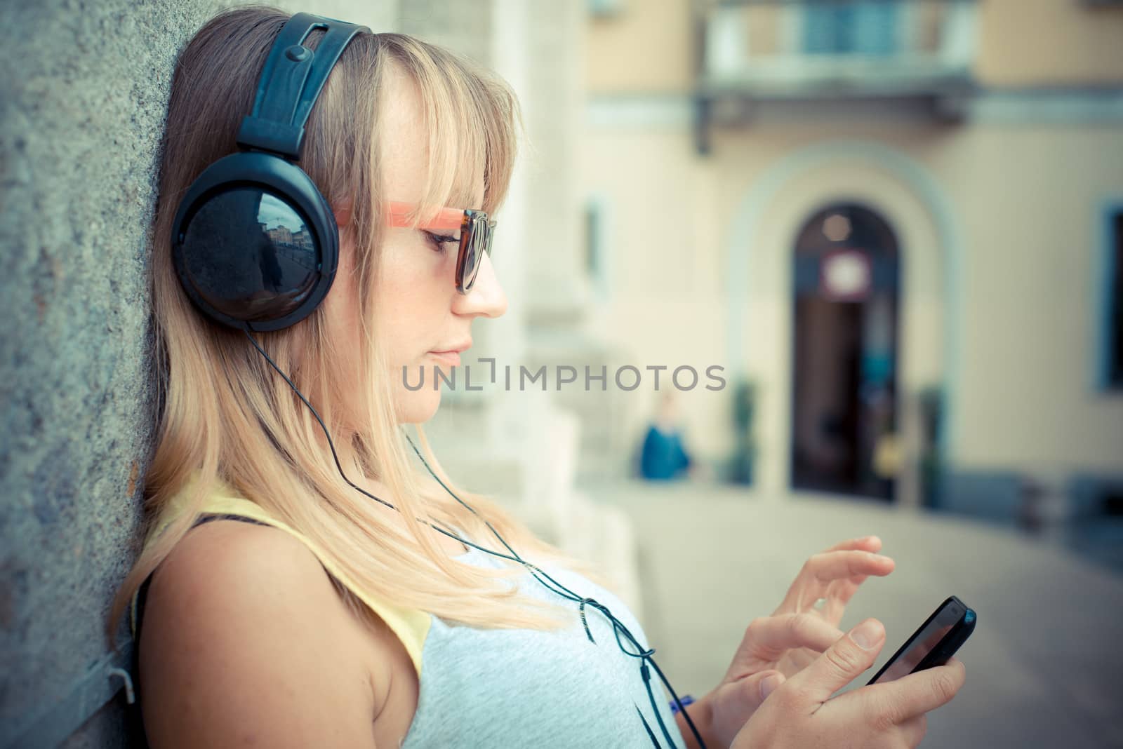 beautiful blonde woman listening to music by peus