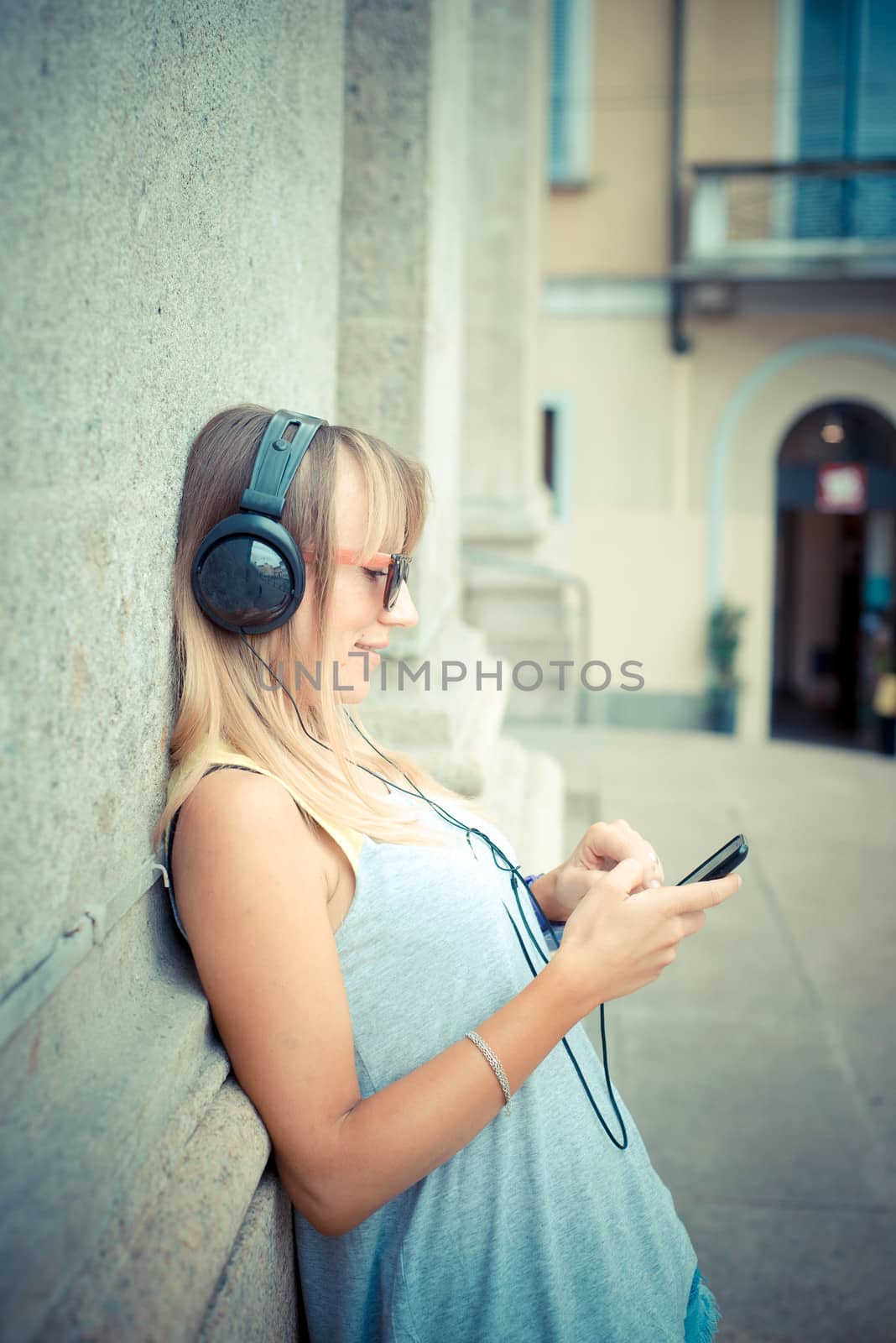 beautiful blonde woman listening to music by peus