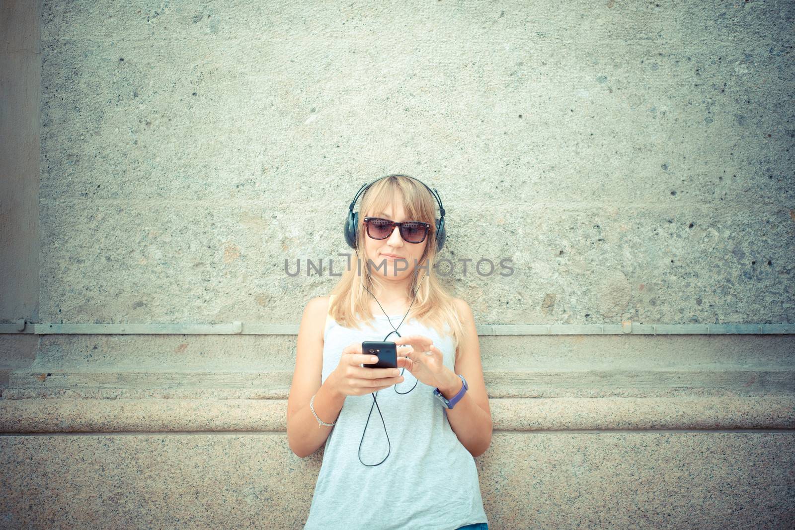 beautiful blonde woman listening to music by peus