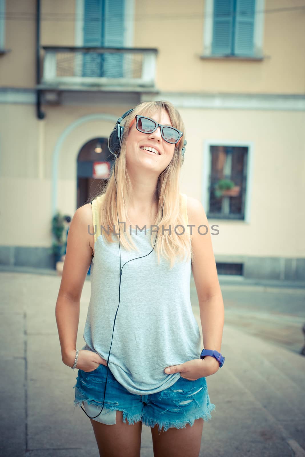 beautiful blonde woman listening to music by peus