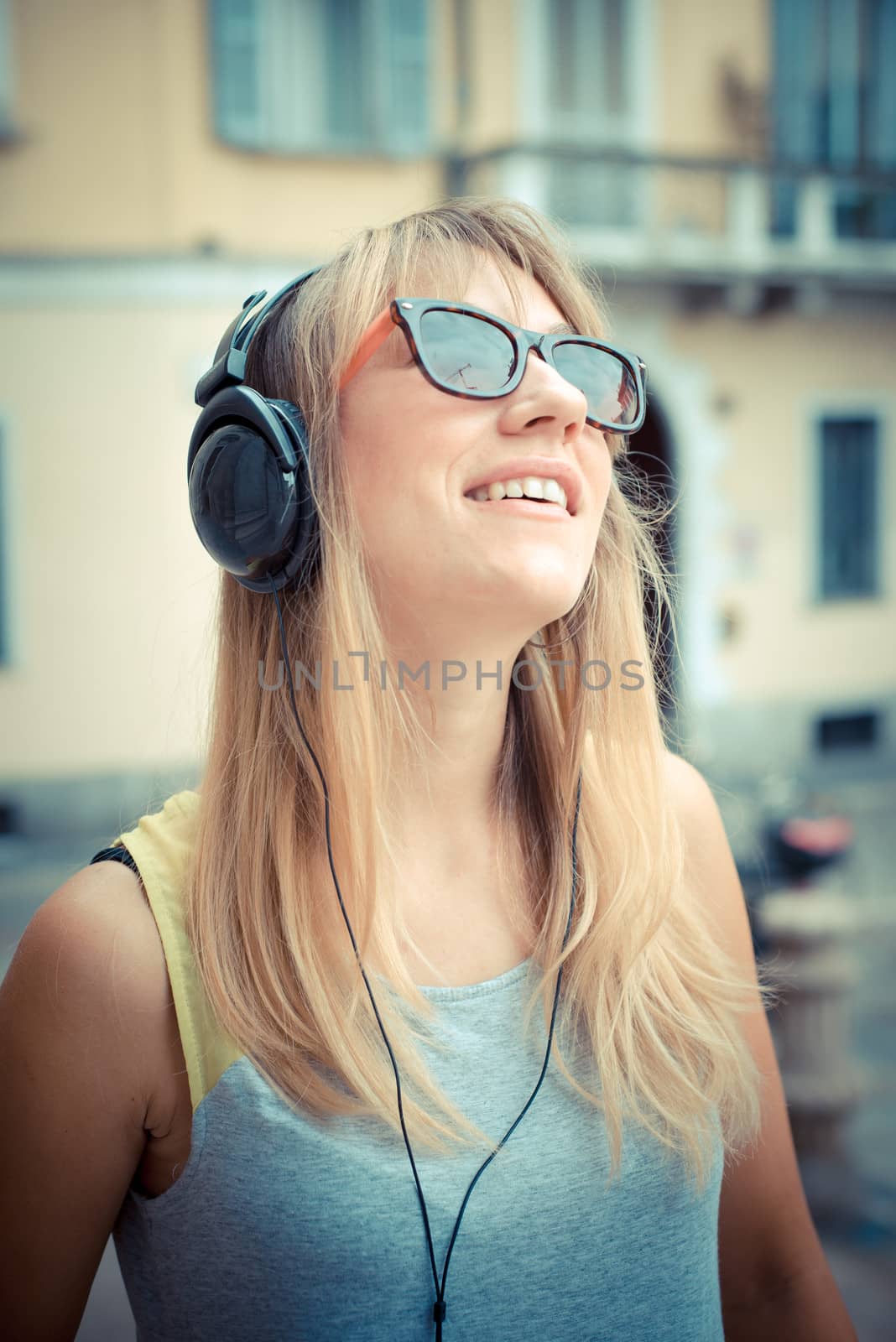 beautiful blonde woman listening to music in the city