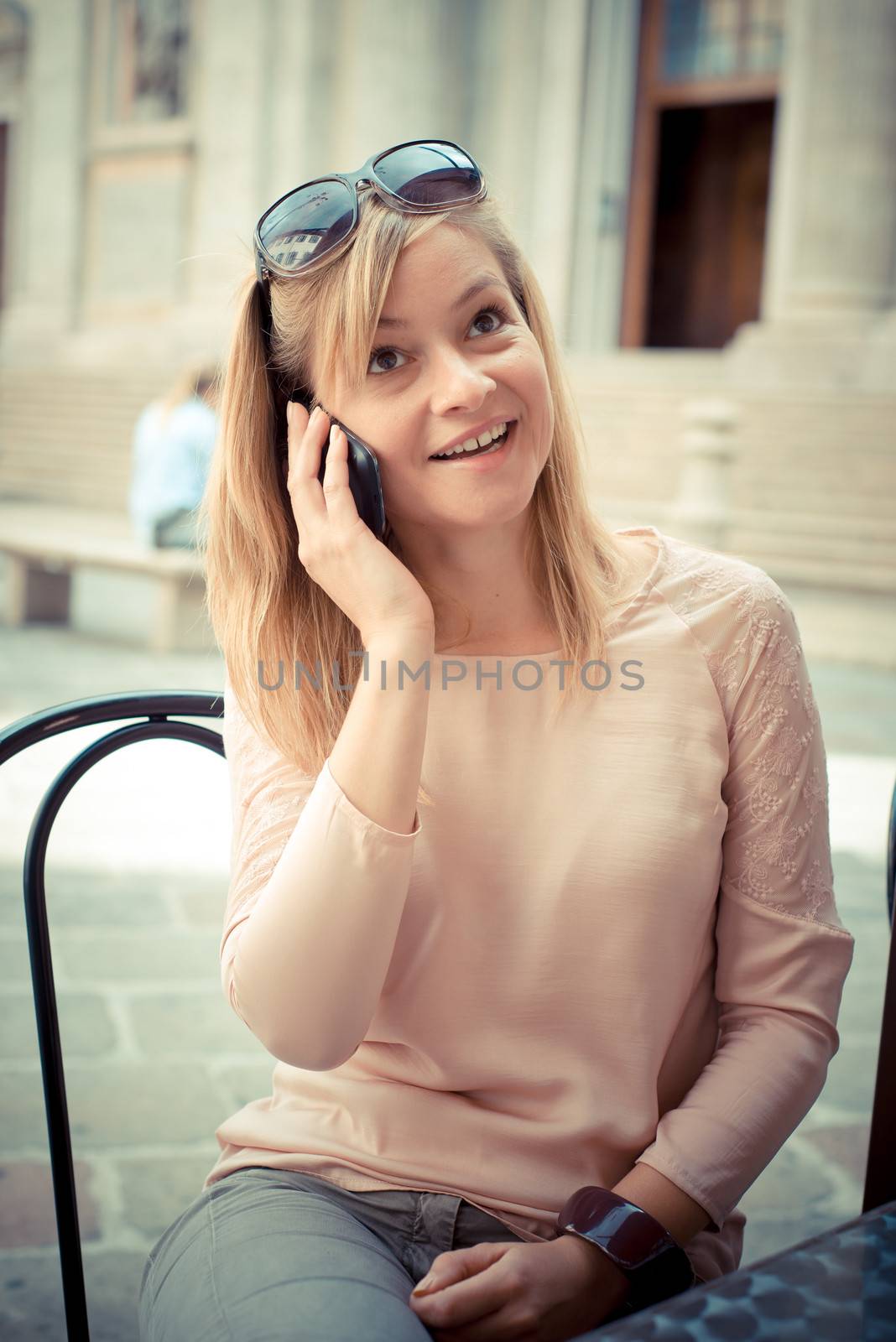 beautiful blonde woman on the phone at the bar by peus