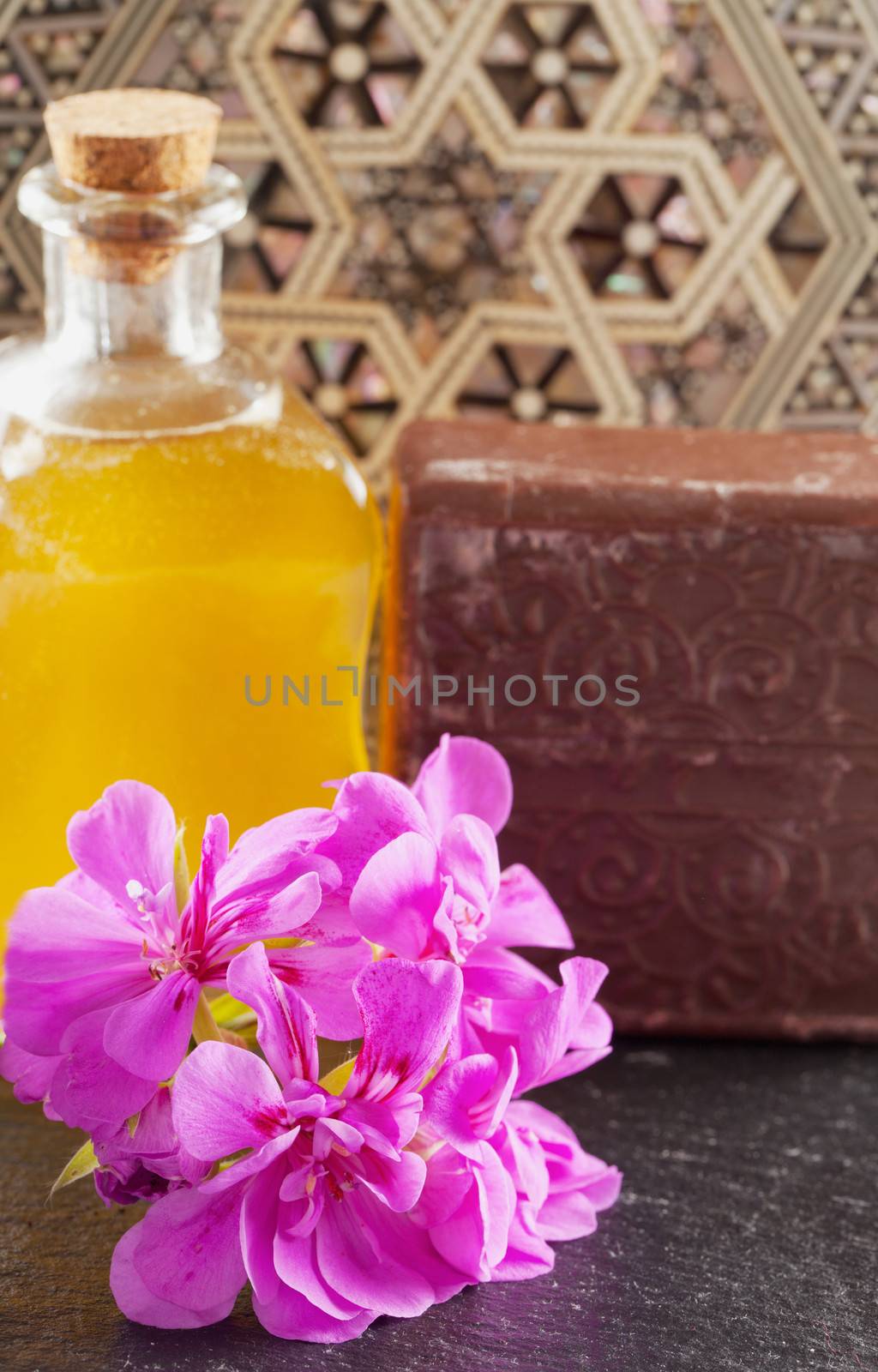 Brown soap, flower and oil over hammam background