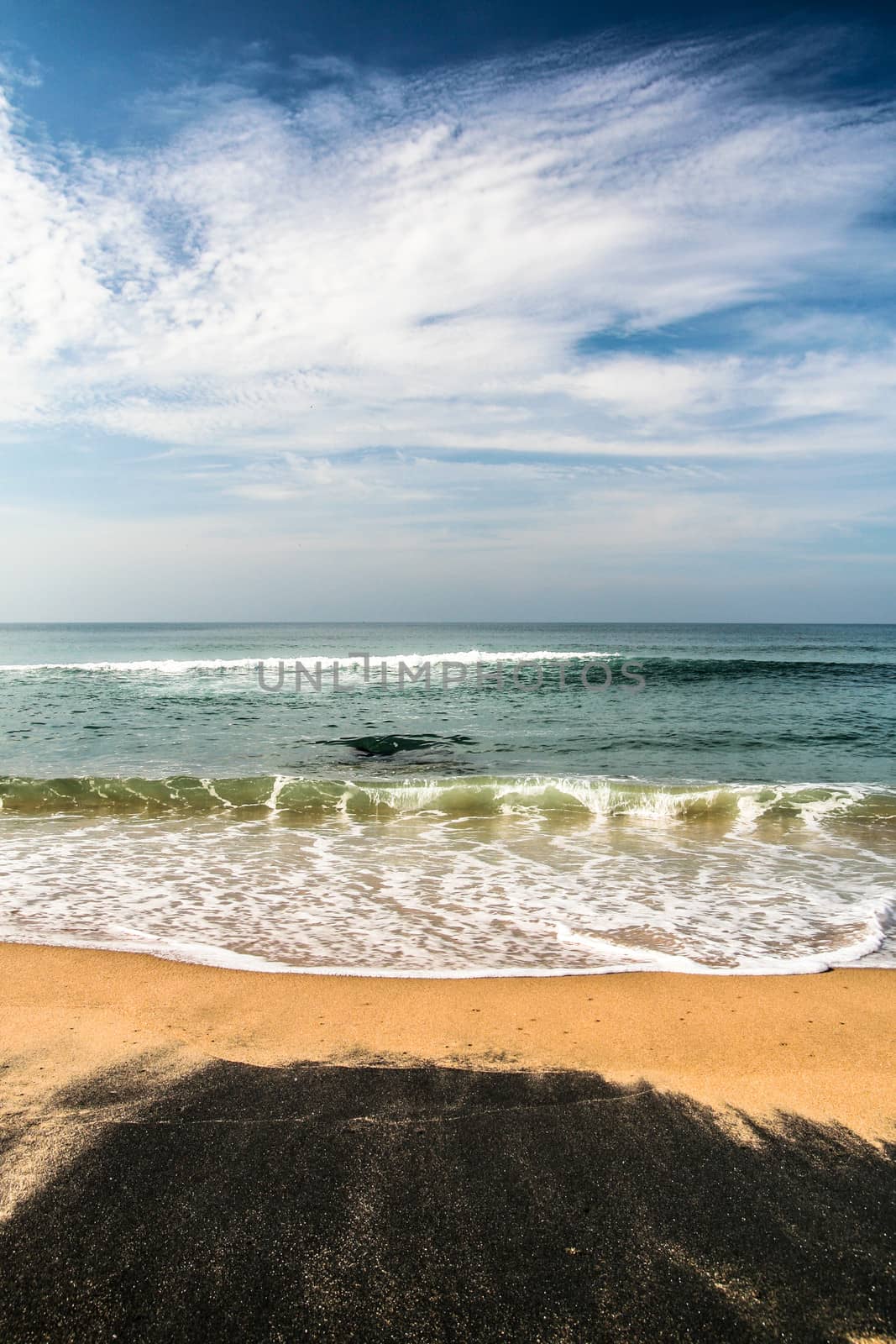 Beautiful blacksand beach in india. Waves hitting in to shore.