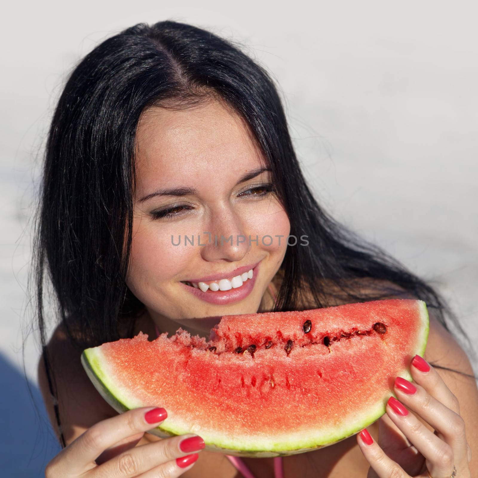 smiling girl eats slice of juicy ripe watermelon