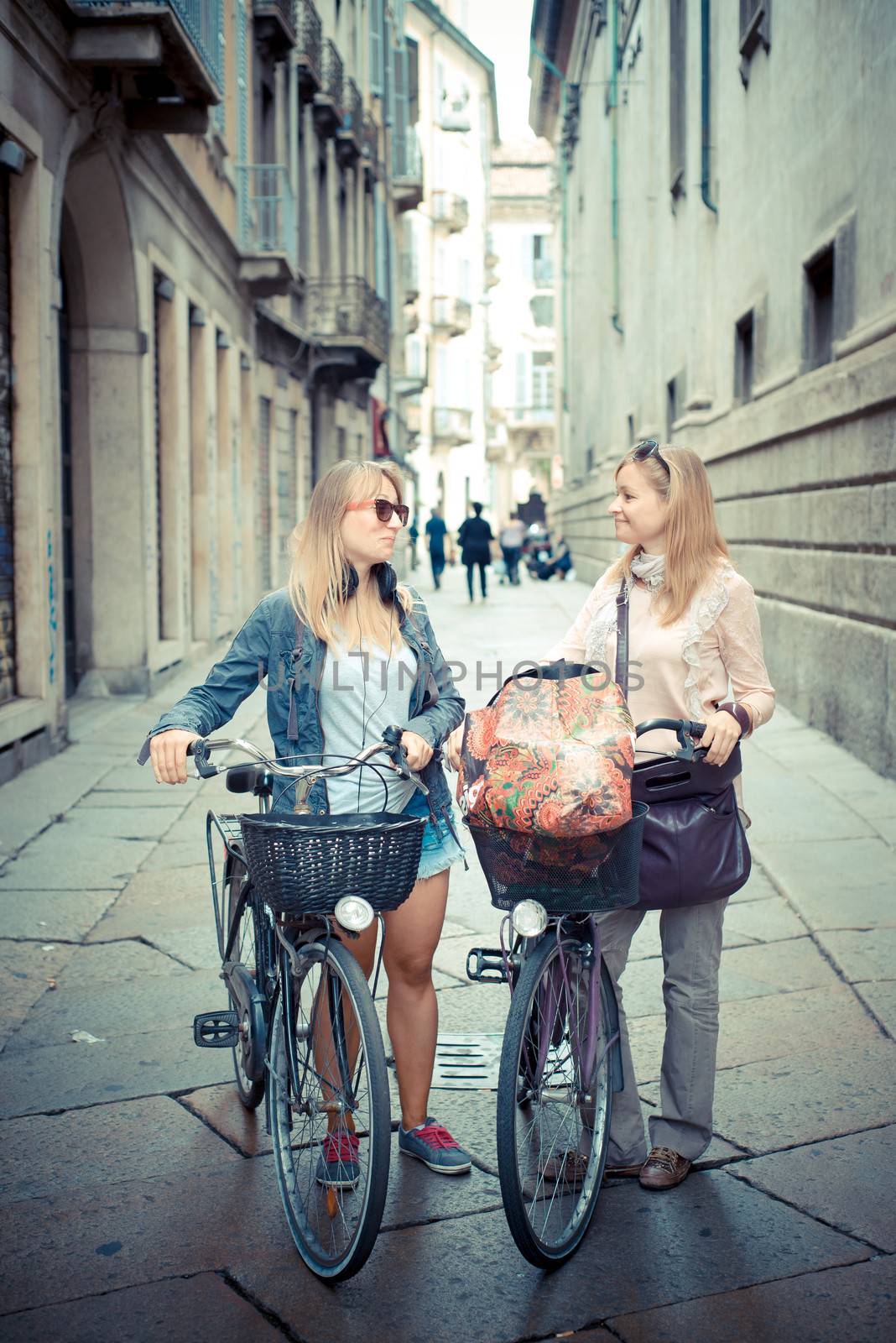 two beautiful blonde women shopping on bike by peus
