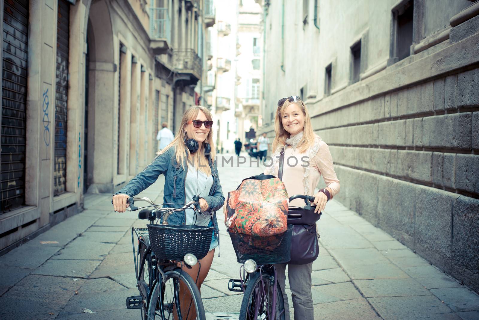 two beautiful blonde women shopping on bike by peus