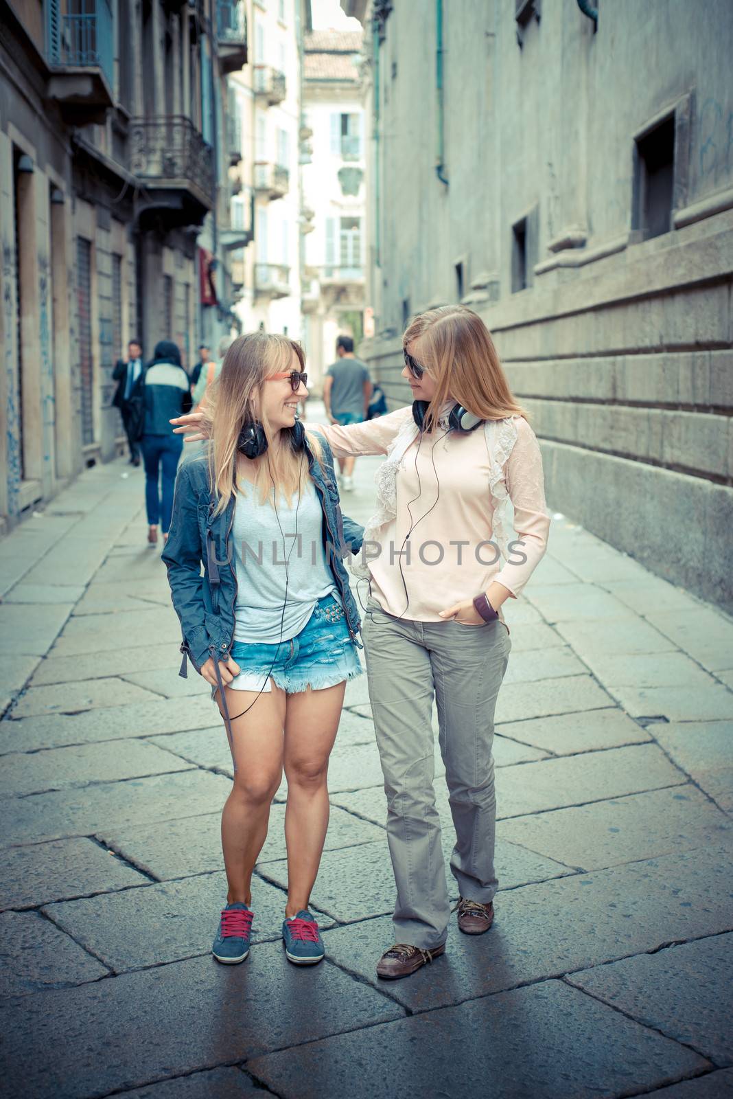 two beautiful blonde women walking and talking by peus