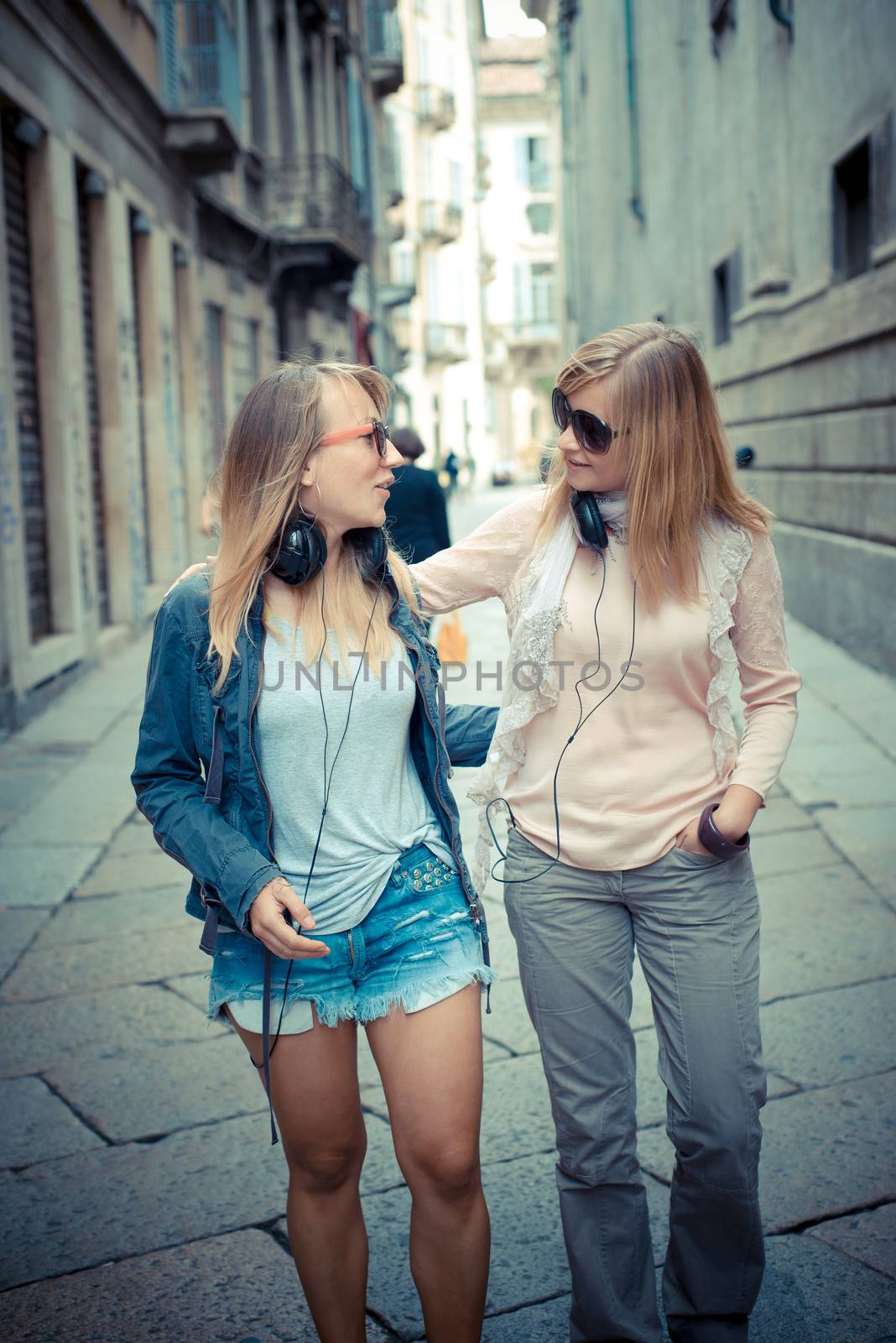 two beautiful blonde women walking and talking by peus
